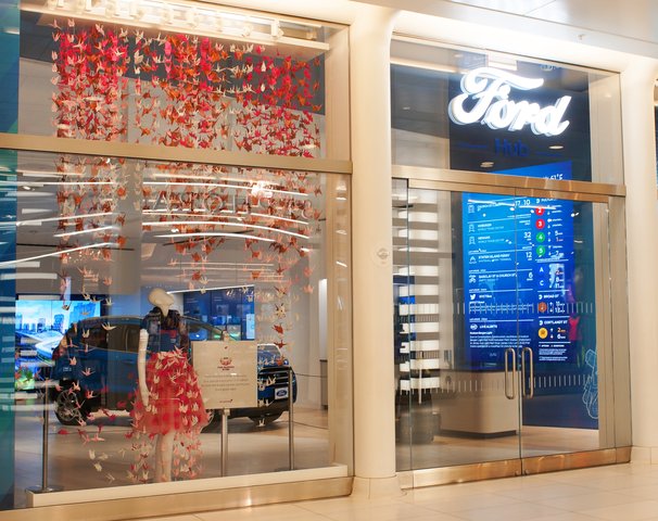 3D display using over 2,000 origami cranes in multiple shades of pink at the FordHub storefront in NYC.