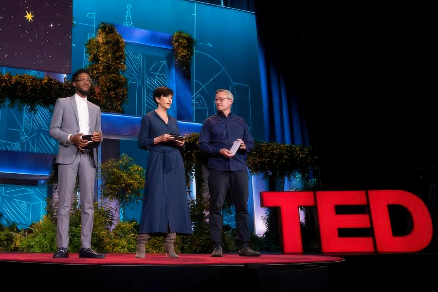 TedX_Countdown_Detroit_06 Three speakers on stage next to illuminated TED logo